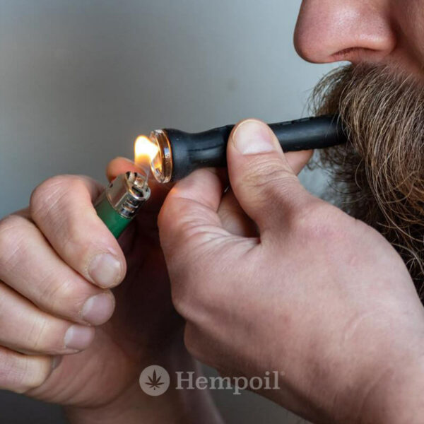 A young man is using a Eyce Shorty Taster Silicone Pipe to smoke cannabis flowers.