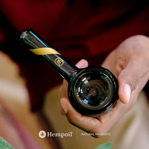 Woman holding the Marley Smoked Glass Spoon Pipe with CBD & CBG Cannabis flowers.